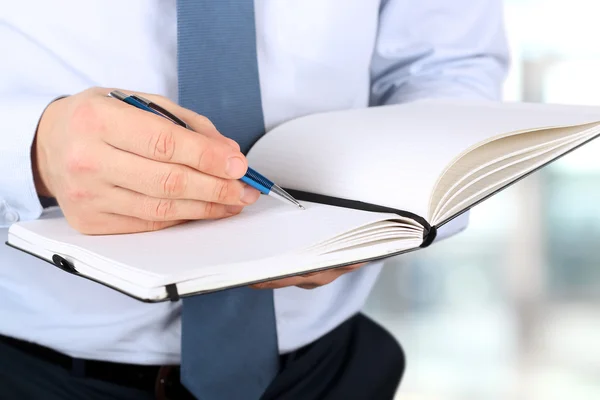 De zakenman schrijven lagen in het notaboek. — Stockfoto