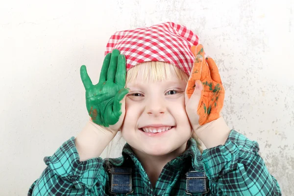 Loira de olhos azuis menina com as mãos na pintura — Fotografia de Stock