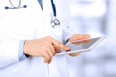Tablet bilgisayarla çalışan doktor.