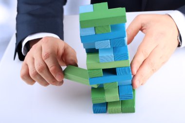 Planlama, risk ve strateji iş, işadamı bir ahşap blok bir kuleden dışarı almak