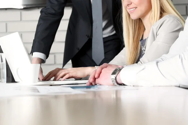 Collega's samenwerken en analyseren van financiële cijfers op een laptop — Stockfoto