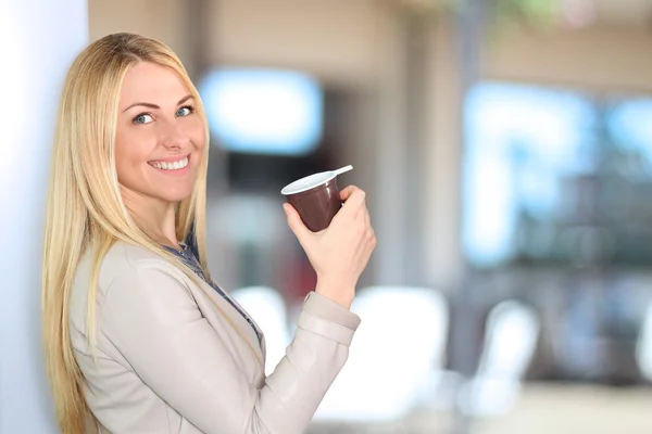 Portret kobiety biznesu, stałego i uśmiechając się z kawą — Zdjęcie stockowe