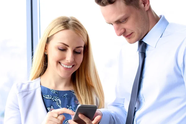 Negocios, trabajo en equipo, personas y concepto de tecnología - gente de negocios con reunión de teléfonos inteligentes en la oficina — Foto de Stock