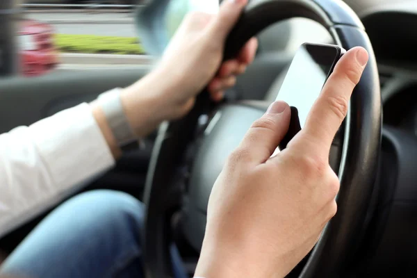 Geschäftsmann nutzt Handy während der Autofahrt — Stockfoto