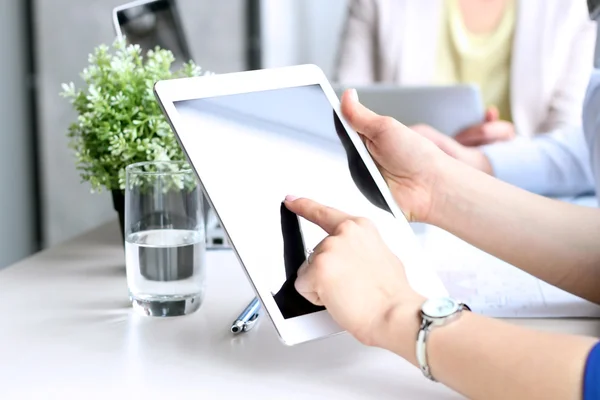 Compañeros de negocios trabajando y analizando cifras financieras en una tableta digital Imagen De Stock