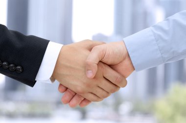 Close-up image of a firm handshake  between two colleagues outside