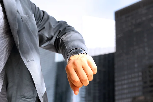 Geschäftsmann kontrolliert die Uhrzeit auf seiner Uhr . — Stockfoto