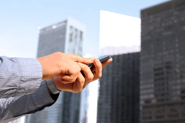 Geschäftsmann, der das Handy draußen hält und benutzt — Stockfoto