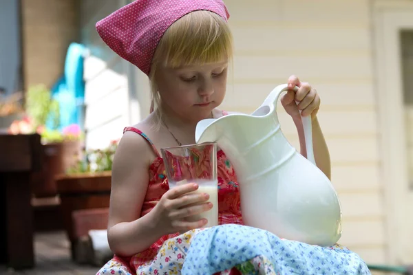 Blondes Mädchen trinkt draußen Milch — Stockfoto