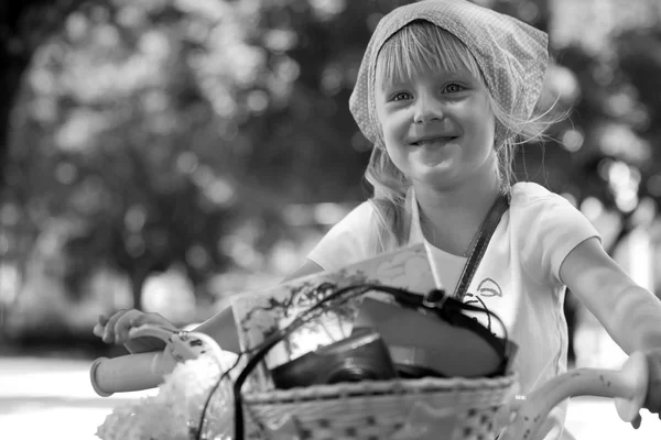 Trevlig liten tjej rida sin cykel på en väg — Stockfoto