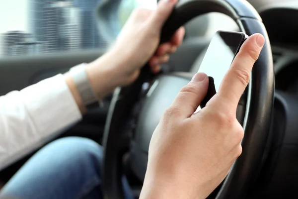 Hombre de negocios usando el teléfono inteligente móvil mientras conduce el coche — Foto de Stock