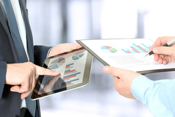 Colegas de negócios trabalhando e analisando números financeiros em um tablet digital — Fotografia de Stock