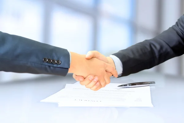 Close-up image of a firm handshake between two colleagues after signing a contract — Stock Photo, Image