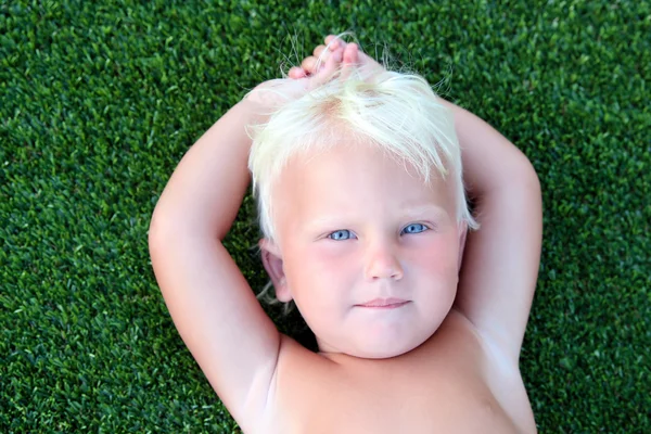 Ler lite blue eyed girl på ett gräs — Stockfoto