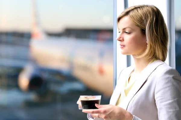 Pencere yakınındaki kahve ile duran iş kadın portresi. Uçağın arka plan — Stok fotoğraf