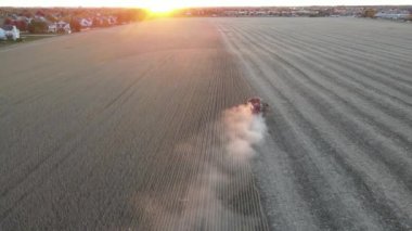 Sonbaharda mısır hasadı. Havadan görünüşlü. Mısır hasadının insansız hava aracı görüntüleri. Gün batımında tarlada çalışan hasat makinesi.