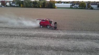 Sonbaharda mısır hasadı. Havadan görünüşlü. Mısır hasadının insansız hava aracı görüntüleri. Gün batımında tarlada çalışan hasat makinesi.