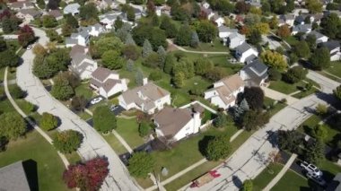 Chicago 'daki banliyö caddesi boyunca bulunan konut ve bahçelerin rengarenk sonbahar ağaçlarının yukarıdan görünüşü. Amerika 'nın orta batısında. 4K