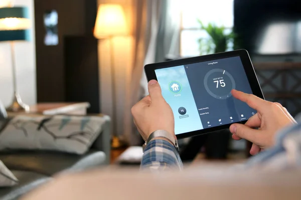Człowiek Dostosowuje Temperaturę Pomocą Tabletu Aplikacją Smart Home Nowoczesnym Salonie — Zdjęcie stockowe