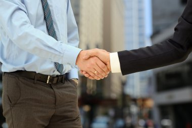 Close-up image of a firm handshake  between two colleagues outsi