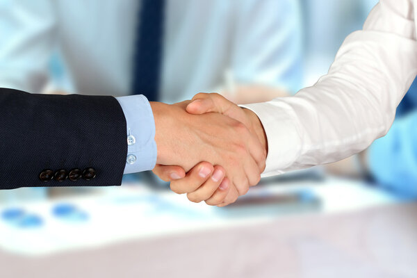 Close-up image of a firm handshake  between two colleagues in of