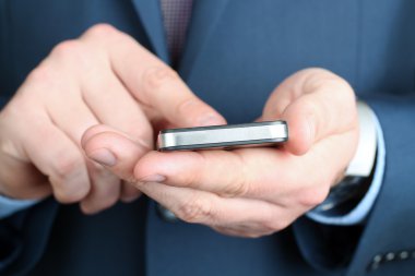Holding ve mobil akıllı telefon kullanan iş adamı
