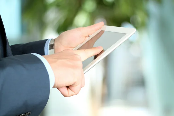 Hombre de negocios sosteniendo y trabajando con una tableta digital — Foto de Stock
