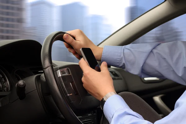 Chaleira usando telefone inteligente móvel durante a condução do carro — Fotografia de Stock