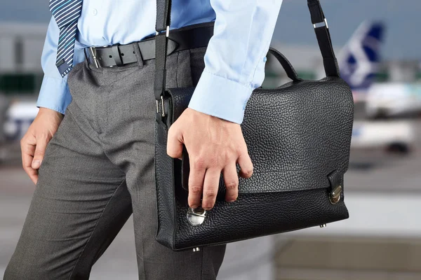 Businessman walking and holding  a  leather briefcase in his han