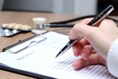 Doktor beyaz bir stetoskop Rx reçeteli yazma içinde