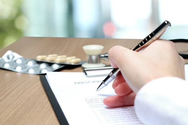 Doctor en una bata blanca escribiendo receta de RX — Foto de Stock