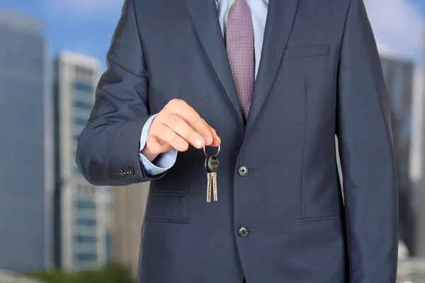 Обрезанное изображение агента по недвижимости, дающего ключи от дома снаружи — стоковое фото