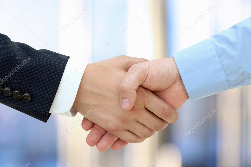 Close-up image of a firm handshake  between two colleagues on a