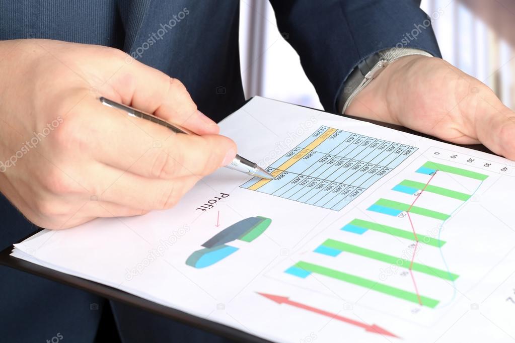 young businessman showing graphs by pen