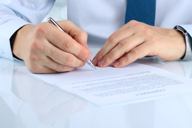 İş adamı kontrat imzalıyor, iş sözleşmesi detayları.