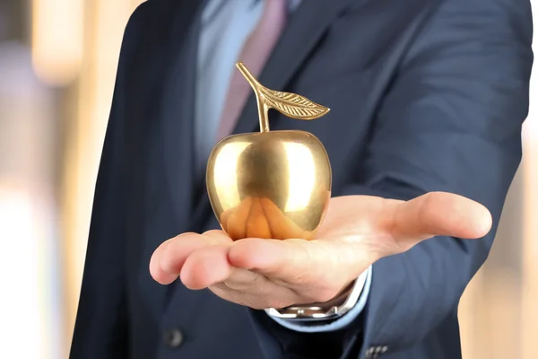 실업가 서 하 고 그의 손에 있는 황금 사과 들고. — 스톡 사진