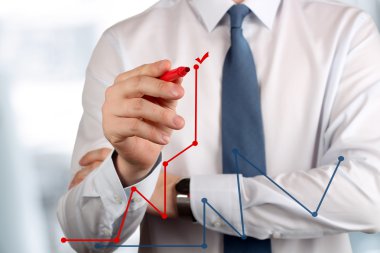 Genç iş adamı tarafından kırmızı kalem bir grafik çizim 