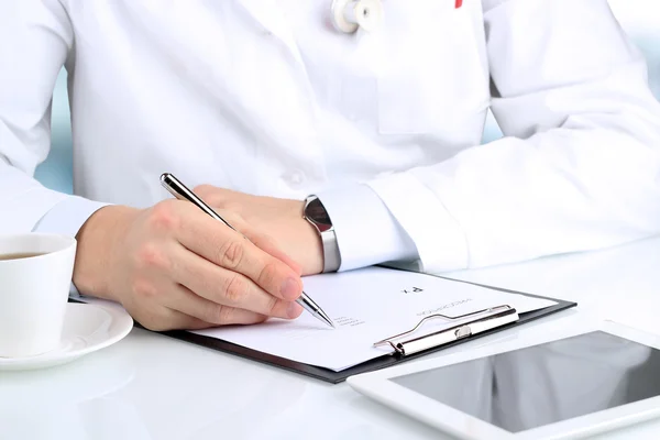 Doktor beyaz bir stetoskop Rx reçeteli yazma içinde