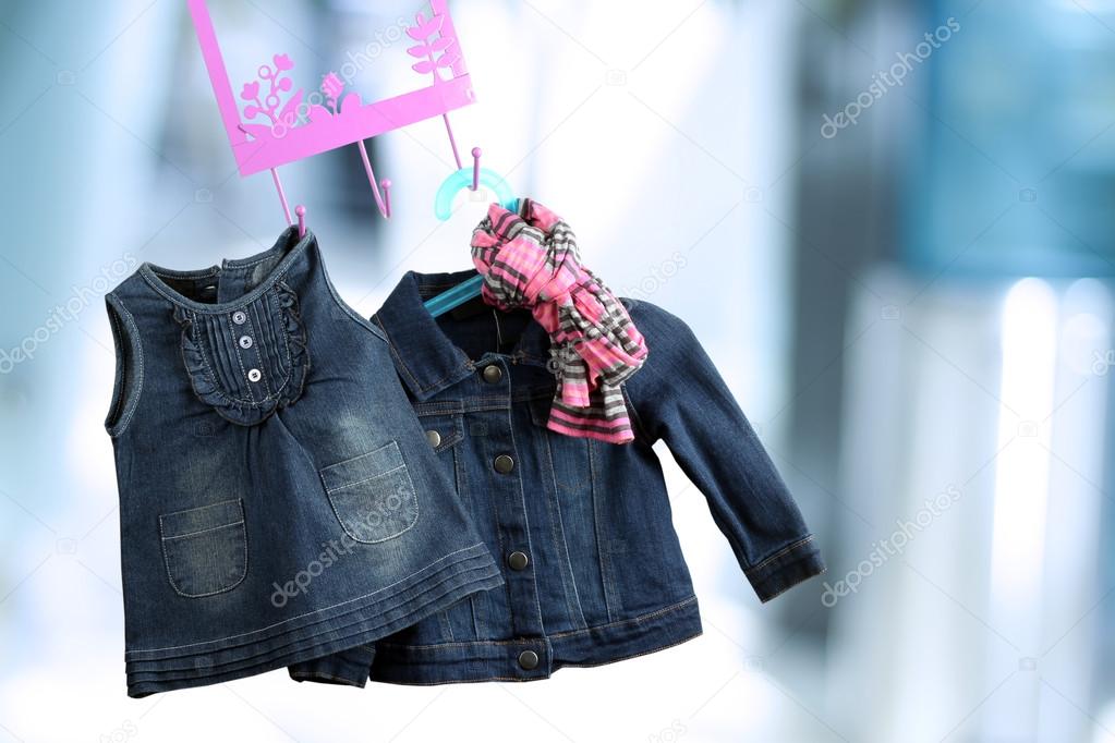 Fashion baby dresses hanging on a hanger on a blue  background