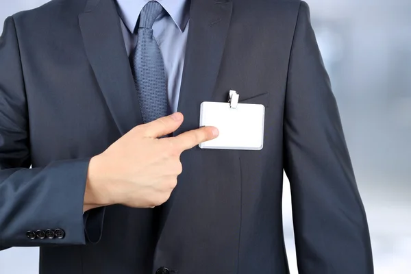 O homem de negócios mostrando um emblema em branco — Fotografia de Stock