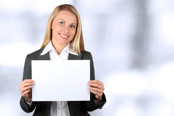 Wanita pengusaha yang bahagia memegang spanduk putih dan tersenyum — Stok Foto