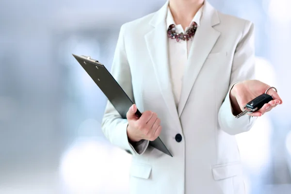 Young successful businesswoman offering a car key. — Stock Photo, Image