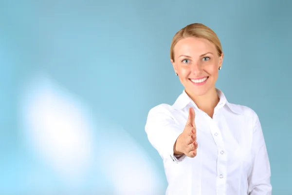 Mujer de negocios dando un apretón de manos sobre un fondo azul — Foto de Stock