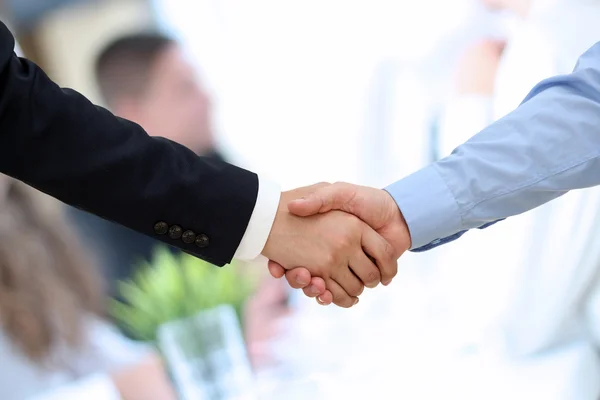 Närbild bild av ett fast handslag mellan två kollegor på kontoret. — Stockfoto