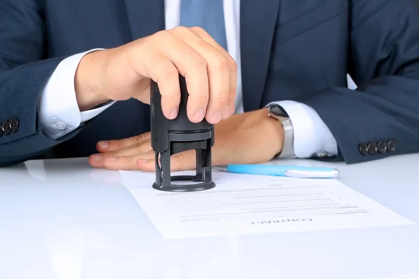 Office belgesinde bir damga bastıktan işadamı elin yakın çekim