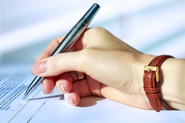 Affärskvinna som sitter vid office skrivbord underteckna ett kontrakt av pen — Stockfoto