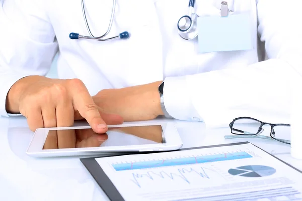 Ιατρός που εργάζεται με μια ψηφιακή δισκίο στο τραπέζι. Καρδιογράφημα με γραφήματα πίσω από — Φωτογραφία Αρχείου