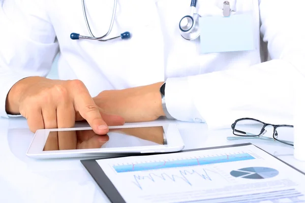 Dijital tablet ile masada çalışan doktor. Kardiyogram grafikleriyle