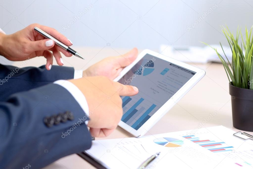 Businesswoman sitting at office desk signing a contract by pen