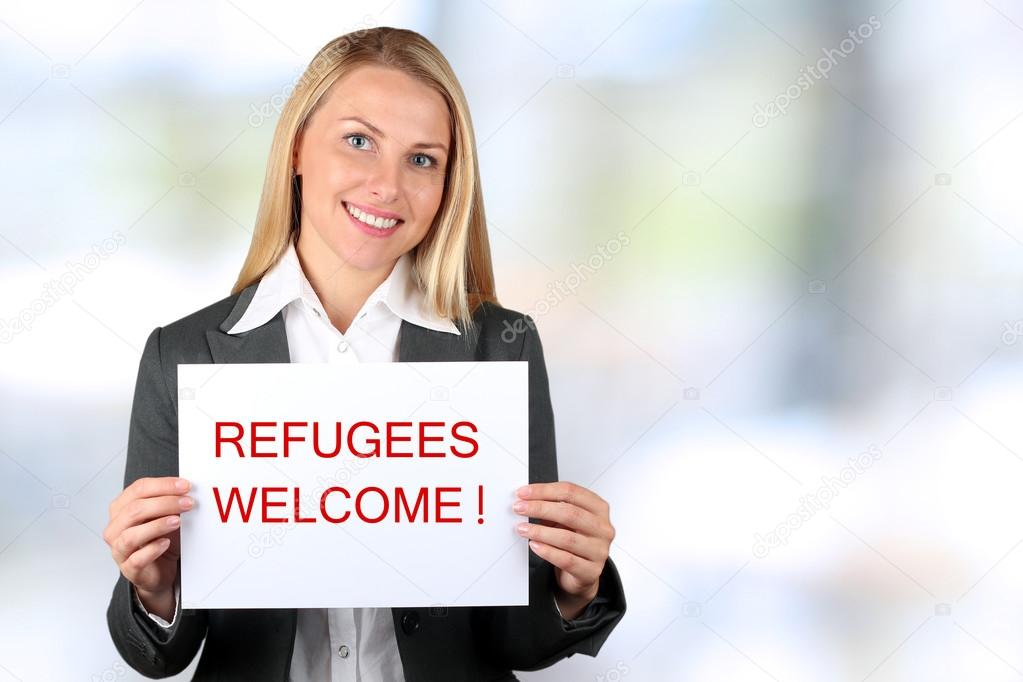 Smiling woman holding a white banner with words 